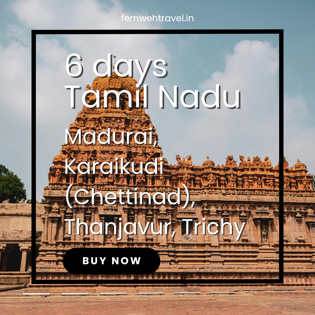 Brihadeeswarar Temple in Thanjavur under blue skies, showcasing towering Dravidian architecture and intricately carved granite.